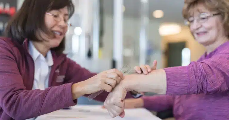 Occupational Therapist Working With Senior Woman On Hand Therapy, Illustrating The Topic Of &Quot;Cpt Codes For Occupational Therapy.&Quot;